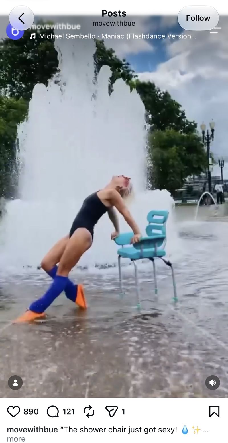 An influencer in a black swimsuit and blue leg warmers dancing with the teal Bue Shower Chair in front of a city fountain